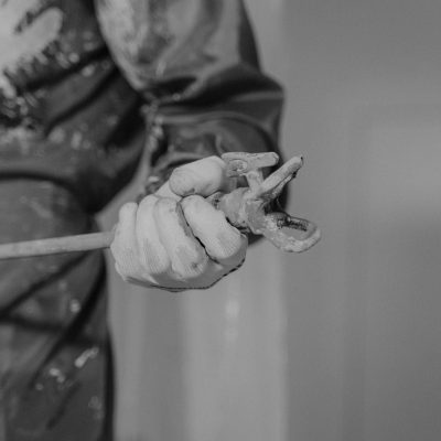 Fixed Monochrome photo featuring a worker's hand gripping a wrench, symbolizing construction.